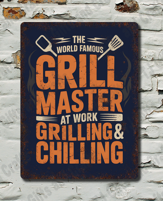 A rectangular metal sign with a distressed dark blue background and bold orange text reading 'GRILL MASTER AT WORK GRILLING & CHILLING,' mounted on a white brick wall with peeling paint.