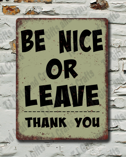 A rectangular vintage-style metal sign with the text 'BE NICE OR LEAVE THANK YOU' in black lettering on a distressed beige background, mounted against a white brick wall with peeling paint.