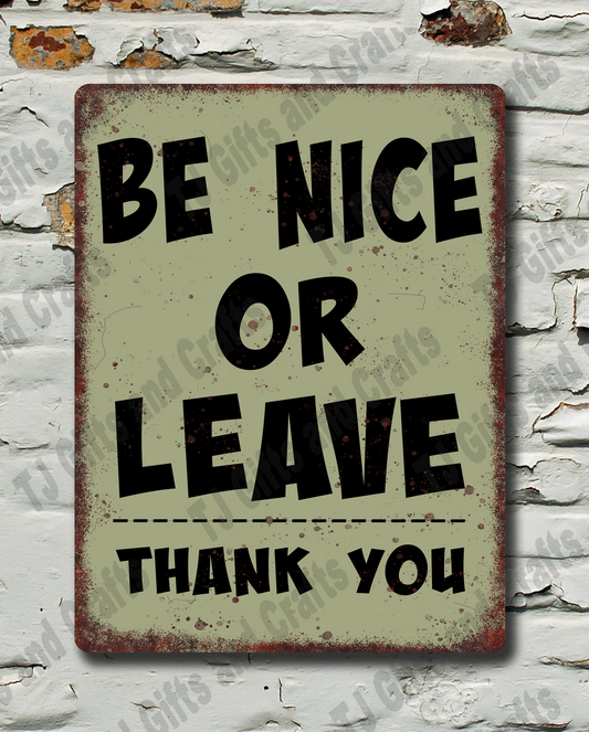 A rectangular vintage-style metal sign with the text 'BE NICE OR LEAVE THANK YOU' in black lettering on a distressed beige background, mounted against a white brick wall with peeling paint.