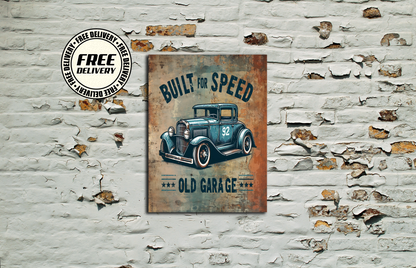 A rectangular vintage-style wall art print hanging on a distressed white brick wall. The print shows an illustrated blue classic car with the text 'BUILT FOR SPEED' and 'OLD GARAGE.