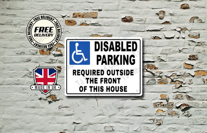 A rectangular white disabled parking sign with a blue handicap symbol and black text reading 'DISABLED PARKING REQUIRED OUTSIDE THE FRONT OF THIS HOUSE,' shown against a distressed white brick wall. A circular 'Free Delivery' badge and a 'Made in UK' shield graphic appear to the left.