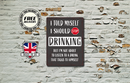 A rectangular dark brown metal sign with white text and a red stop symbol, displayed against a distressed white brick wall. The sign reads: 'I TOLD MYSELF I SHOULD STOP DRINKING BUT I'M NOT ABOUT TO LISTEN TO A DRUNK THAT TALKS TO HIMSELF'.