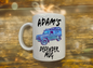 Mug with a graphic of a Land Rover Defender and text 'Adam's Defender Mug' on a wooden background