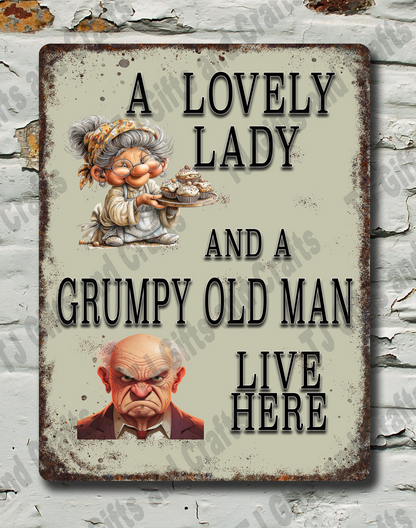 A rectangular vintage-style metal sign with a distressed cream background and dark brown border, mounted on a white brick wall with peeling paint. The sign features the text 'A LOVELY LADY AND A GRUMPY OLD MAN LIVE HERE' with small illustrations of a woman and an old man.