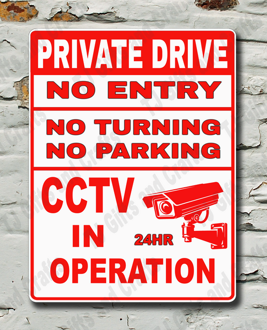 A rectangular red and white warning sign reading 'PRIVATE DRIVE NO ENTRY NO TURNING NO PARKING CCTV IN OPERATION' with a CCTV camera icon, mounted on a distressed white brick wall.