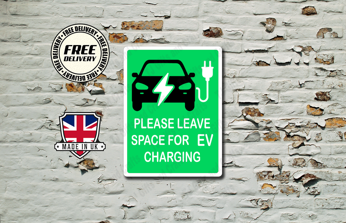 A green rectangular sign with a black electric car and charging plug icon, plus the text 'PLEASE LEAVE SPACE FOR EV CHARGING,' displayed against a distressed white brick wall. Two circular badges appear to the left reading 'FREE DELIVERY' and 'MADE IN UK.