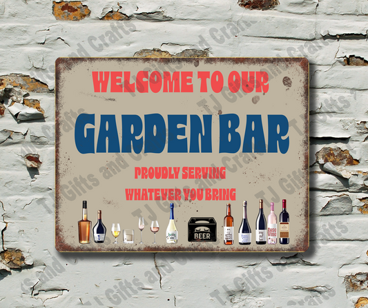 A rectangular vintage-style metal sign reading 'WELCOME TO OUR GARDEN BAR' with red and blue lettering and small illustrated bottles along the bottom, mounted on a distressed white brick wall.